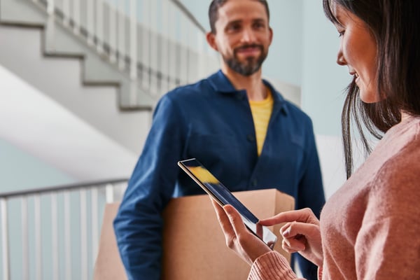 A courier is delivering an IKEA package to a customer at home