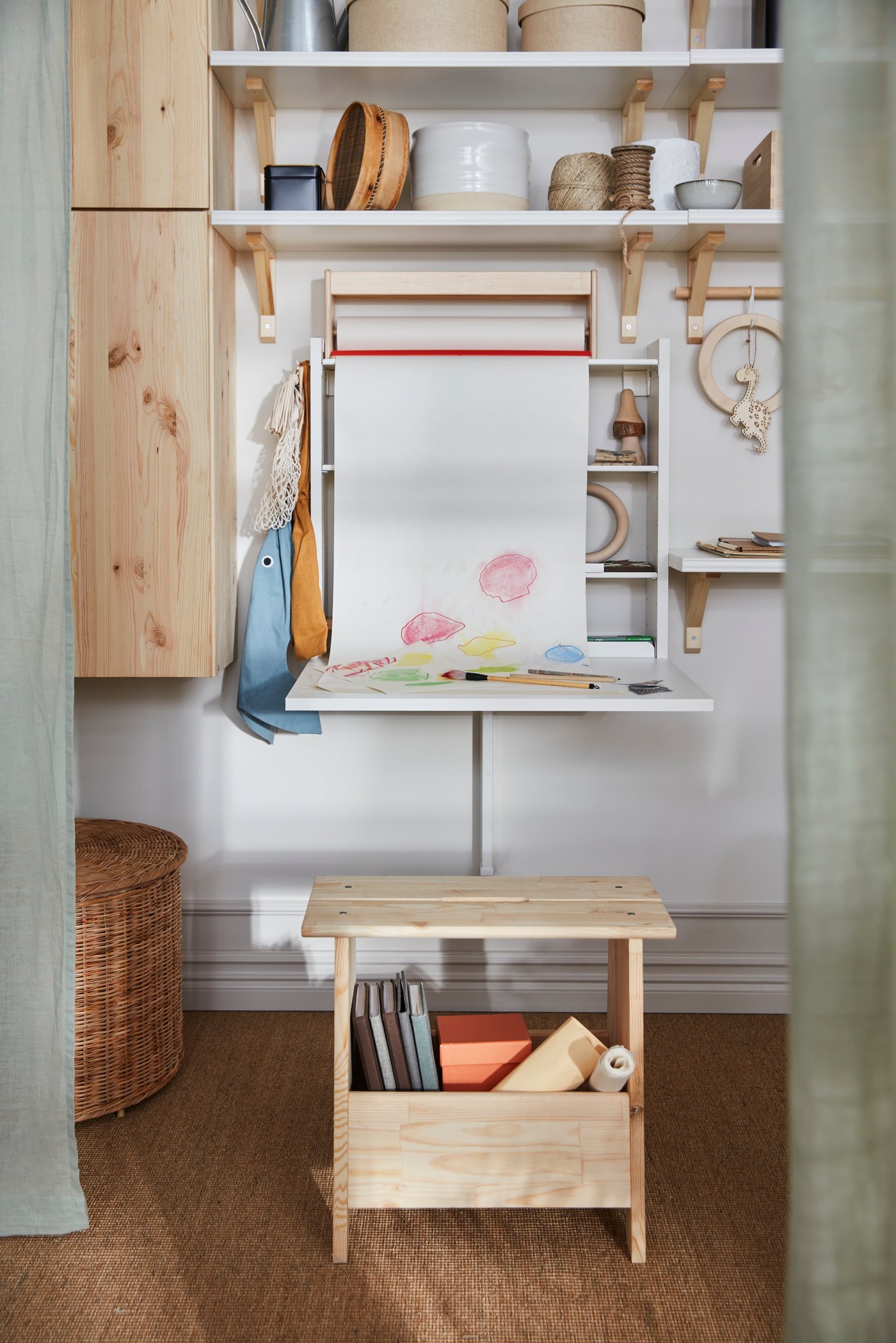 Una mesa de pared NORBERG blanca y sobre ella materiales para manualidades infantiles.