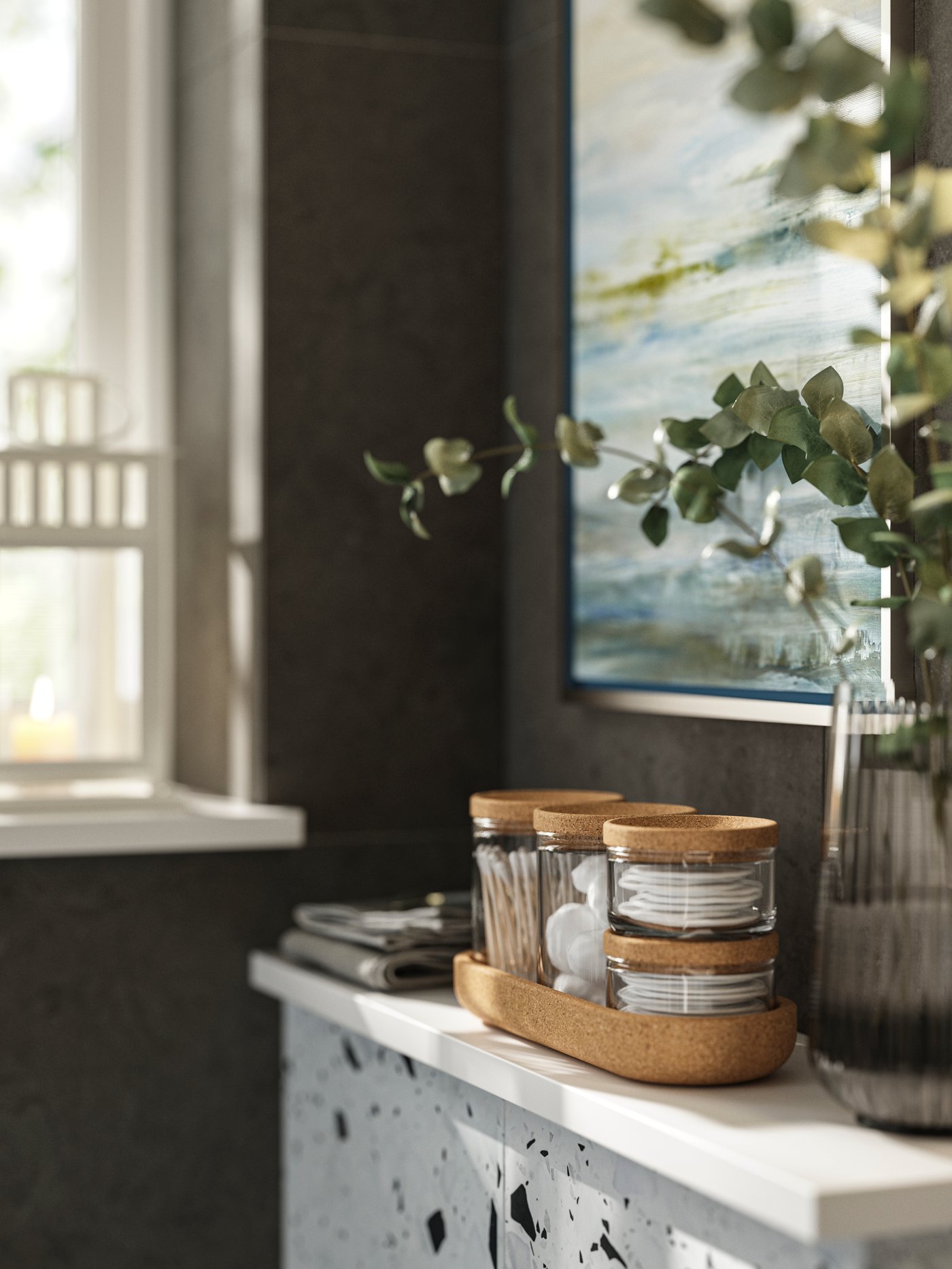A set of SAXBORGA glass jars and boxes with lid and tray in cork sits on a white chest of drawers close to a large window.