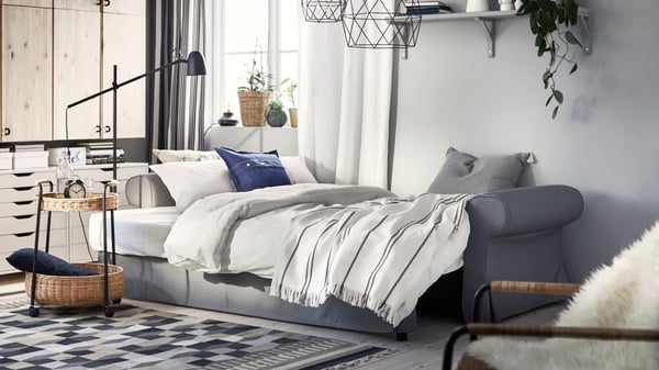Sklopljeni VRETSTORP sofa ležaj s belom posteljinom.