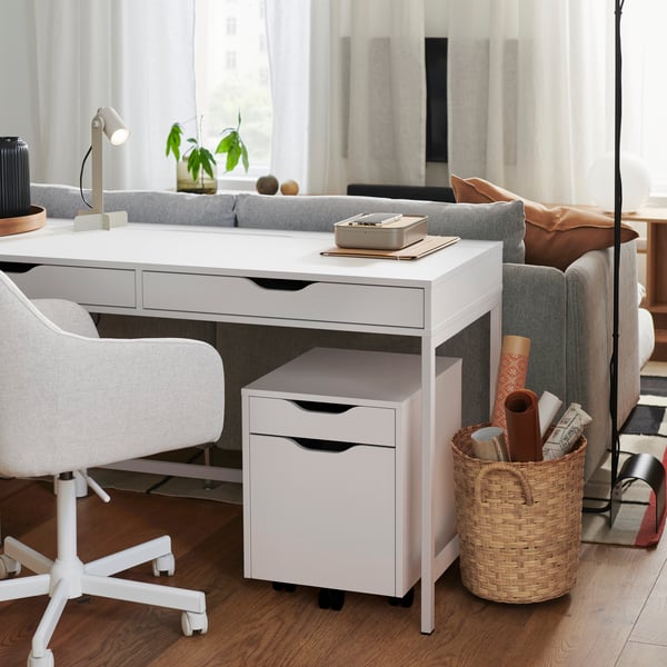 Une chaise pivotante MALSKÄR beige et blanche de Gunnared devant le bureau ALEX