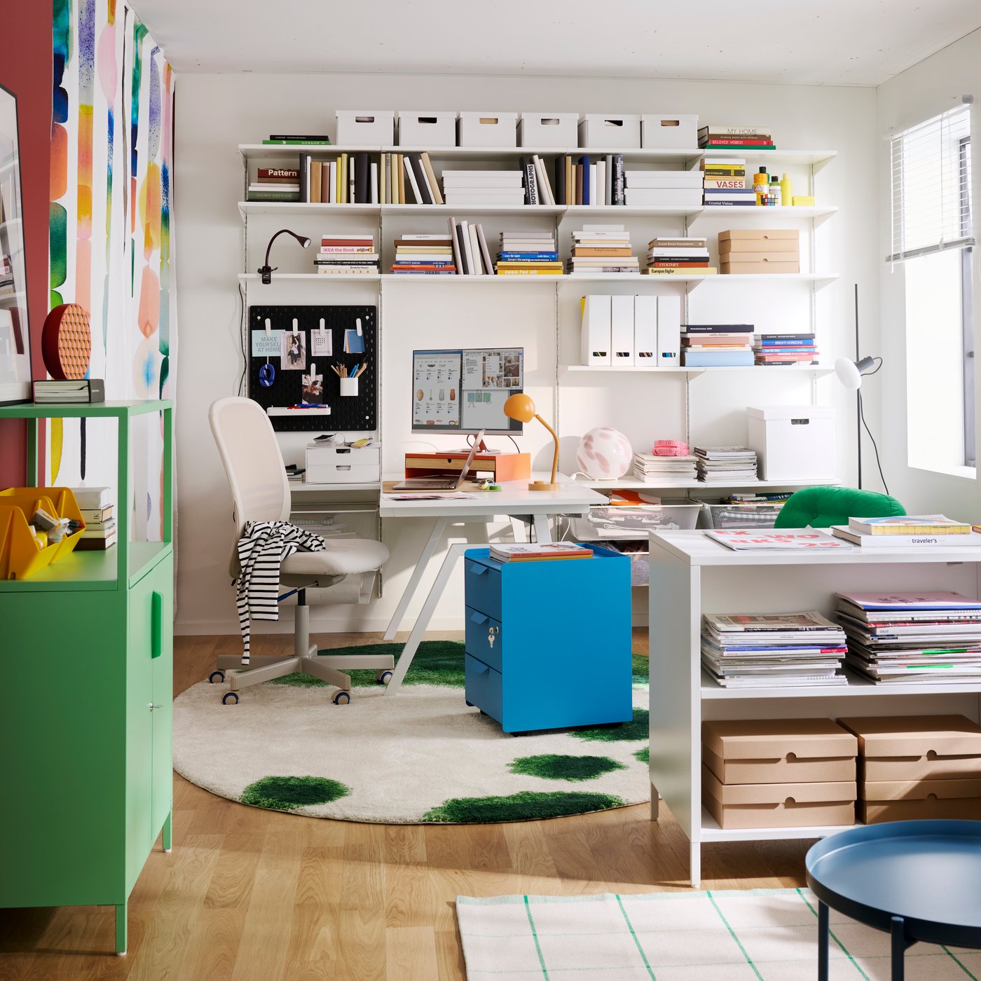 A home office features a blue TROTTEN drawer unit on castors, surrounded by shelves and a desk with stationery.