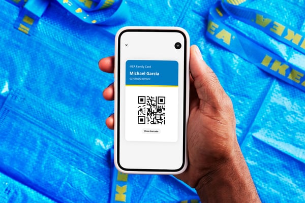 A person holding a phone showing IKEA Family membership card