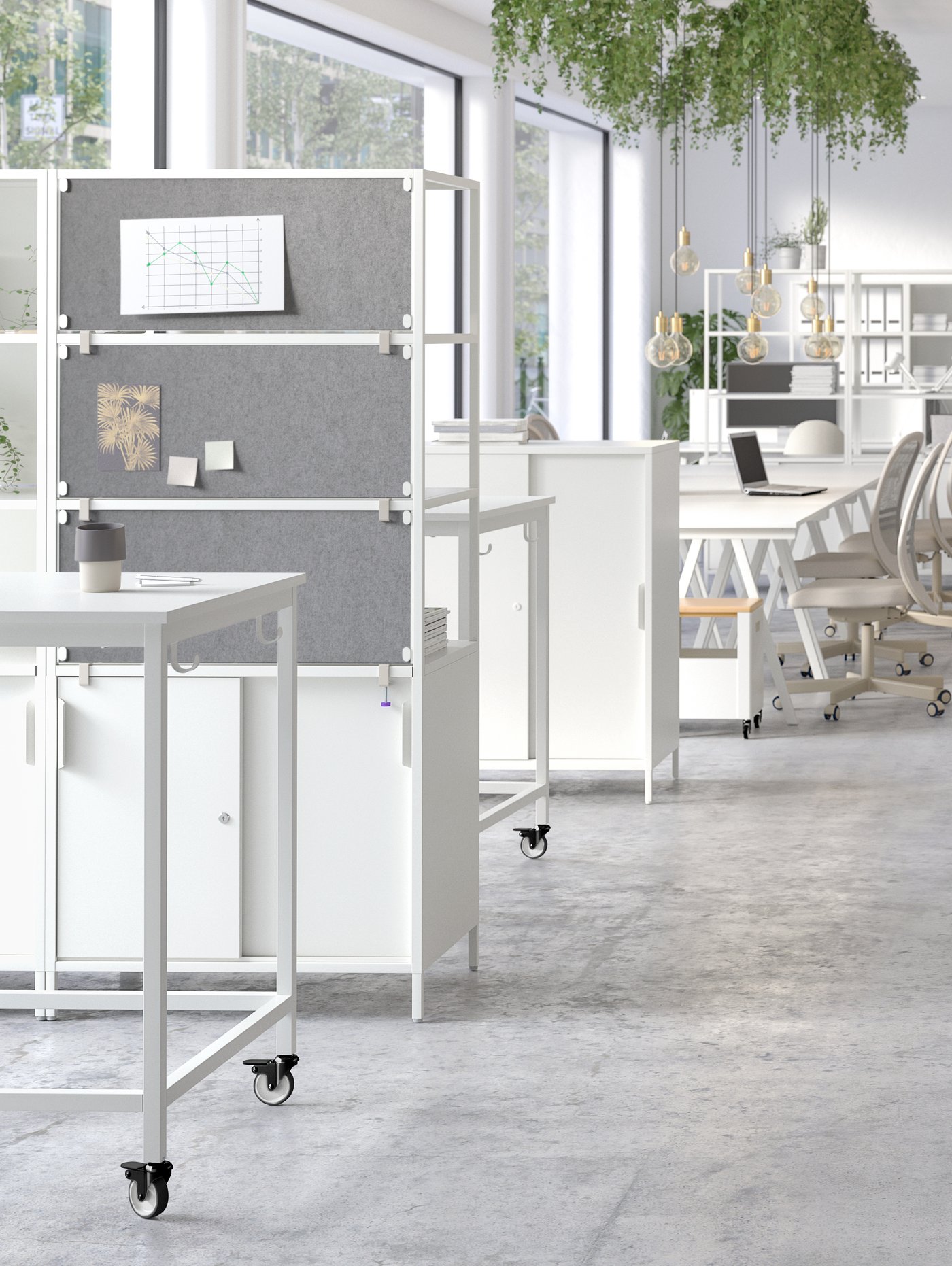 An airy office with white TROTTEN double-sided cabinets with open and closed storage used as room dividers.