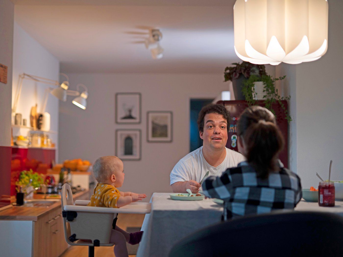 Muškarac, žena i malo dete sede za kuhinjskim stolom
