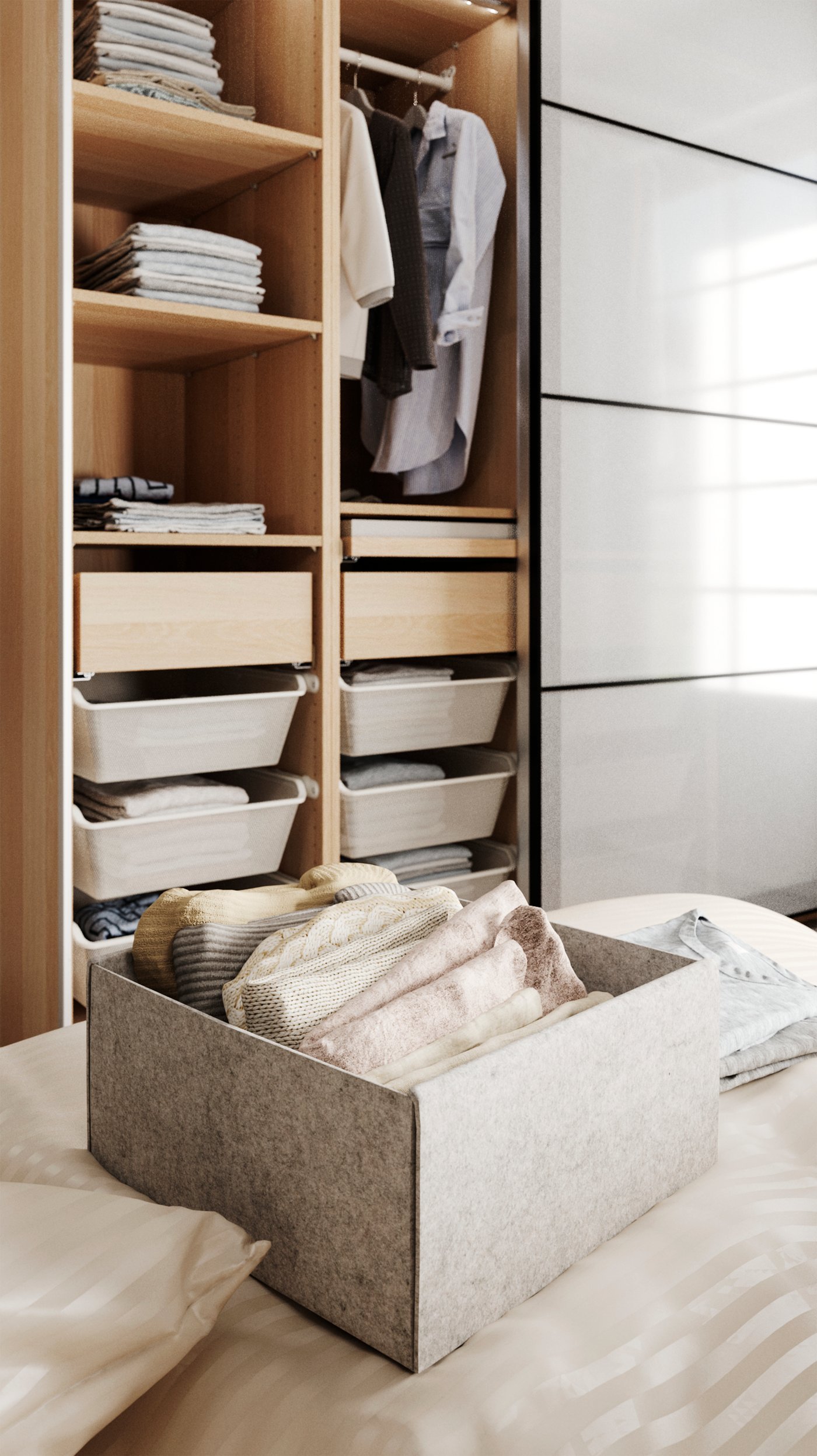 Eine KOMPLEMENT Box auf einem Bett. In der Box sind gefaltete Kleidungsstücke zu sehen. Dahinter steht an der Wand ein geöffneter Kleiderschrank mit verschiedenen Fächern.