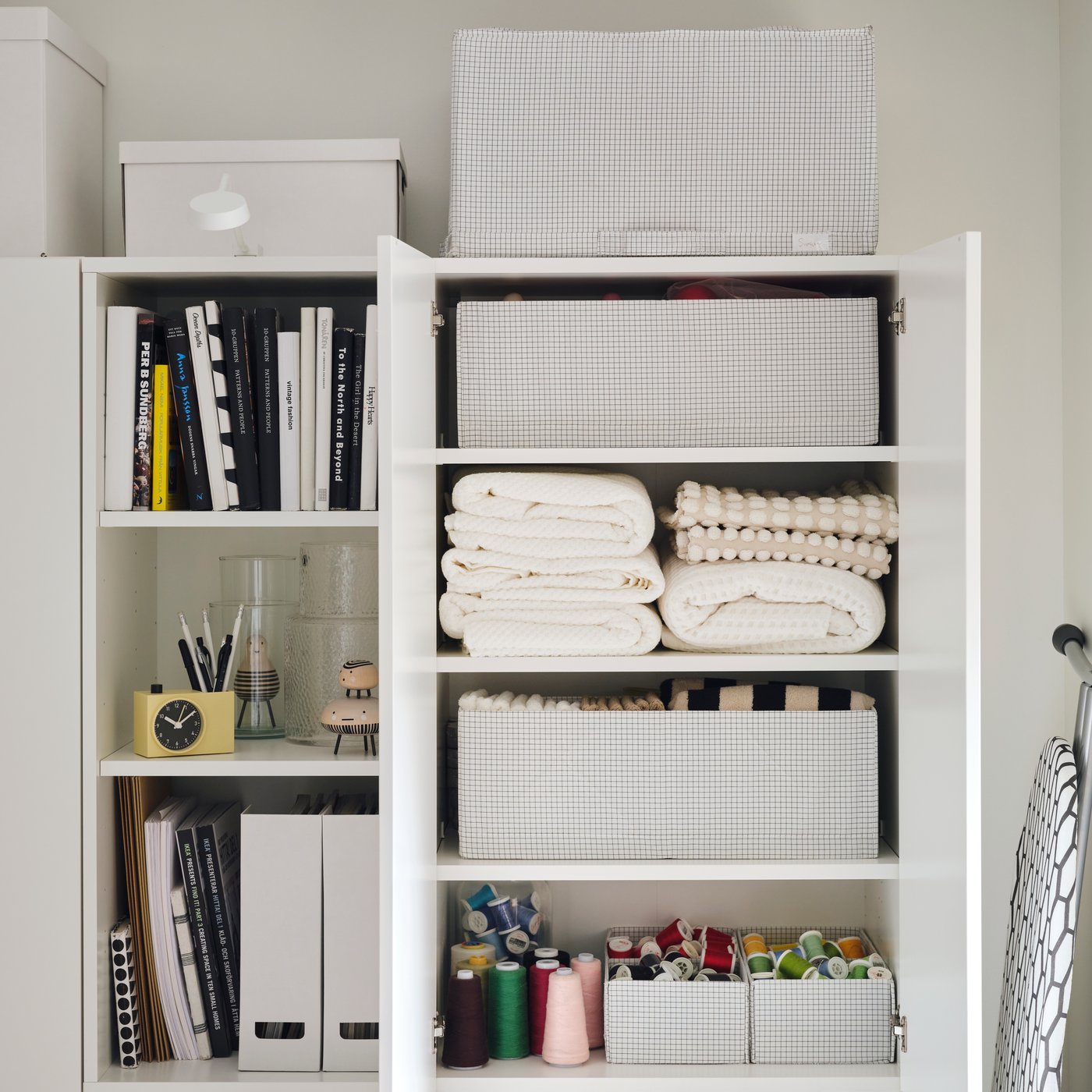A neatly organised wardrobe with STUK accessories holding towels, books and smaller craft items on a shelving unit.