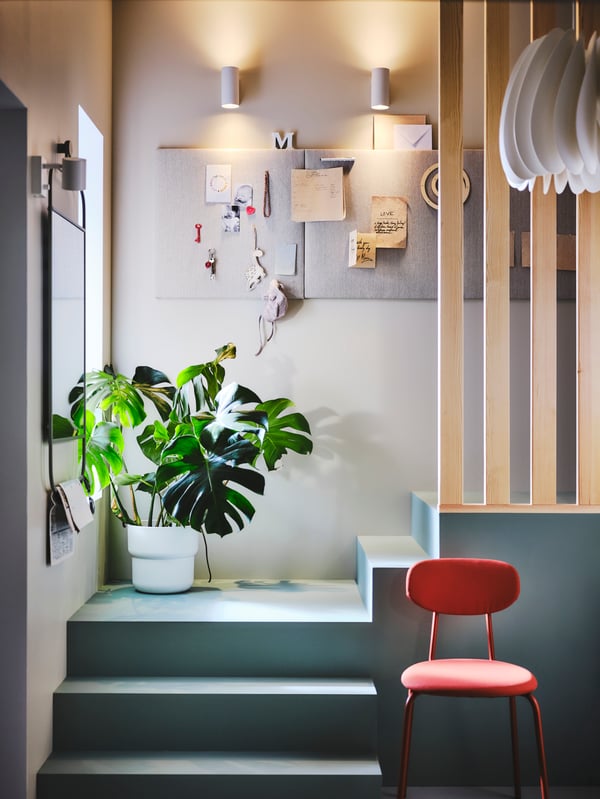 Dve NYMÅNE zidne/čitaće lampe na zidu ispred dve SVENSÅS table u dnu stepeništa na kom je biljka.