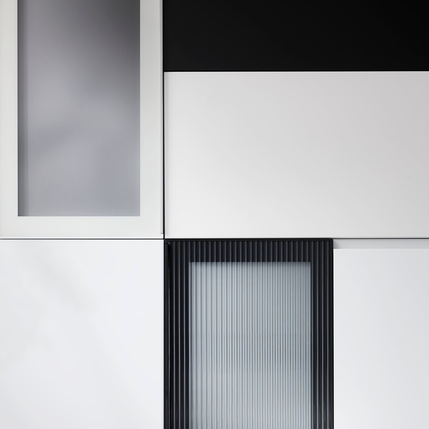 Differently-coloured kitchen fronts with modern expressions are placed in a graphic pattern against a dark background.