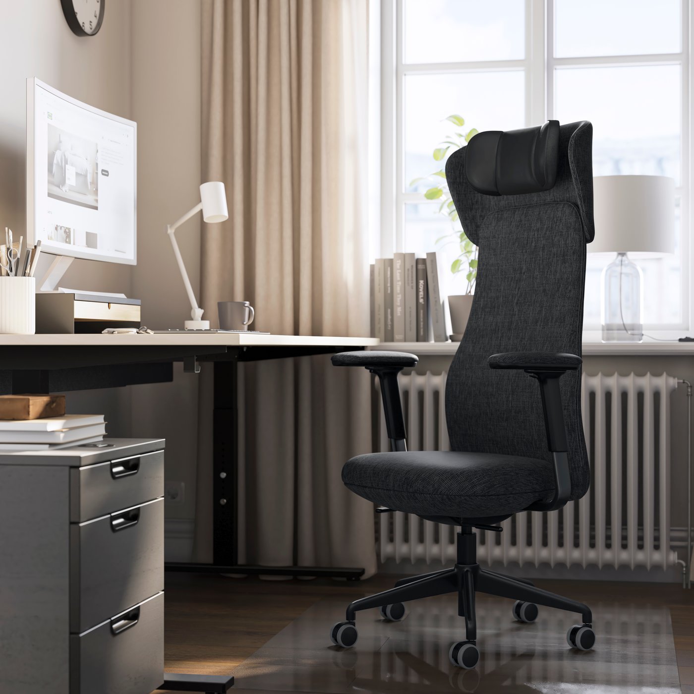 Une chaise de bureau GRÖNFJÄLL gris-noir est placée devant un bureau.