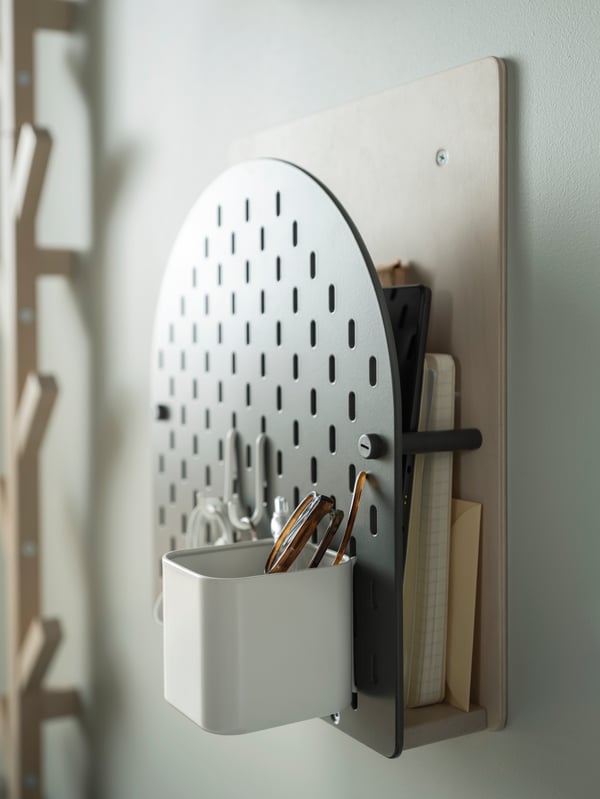 A green-and-wood VATTENKAR wall storage, with SKÅDIS pegboard accessories arranged on its pegboard front.