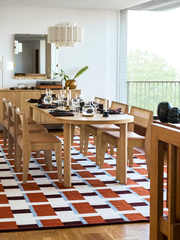 An oak veneer STOCKHOLM 2025 dining table, dining chairs and rug in the dining room.