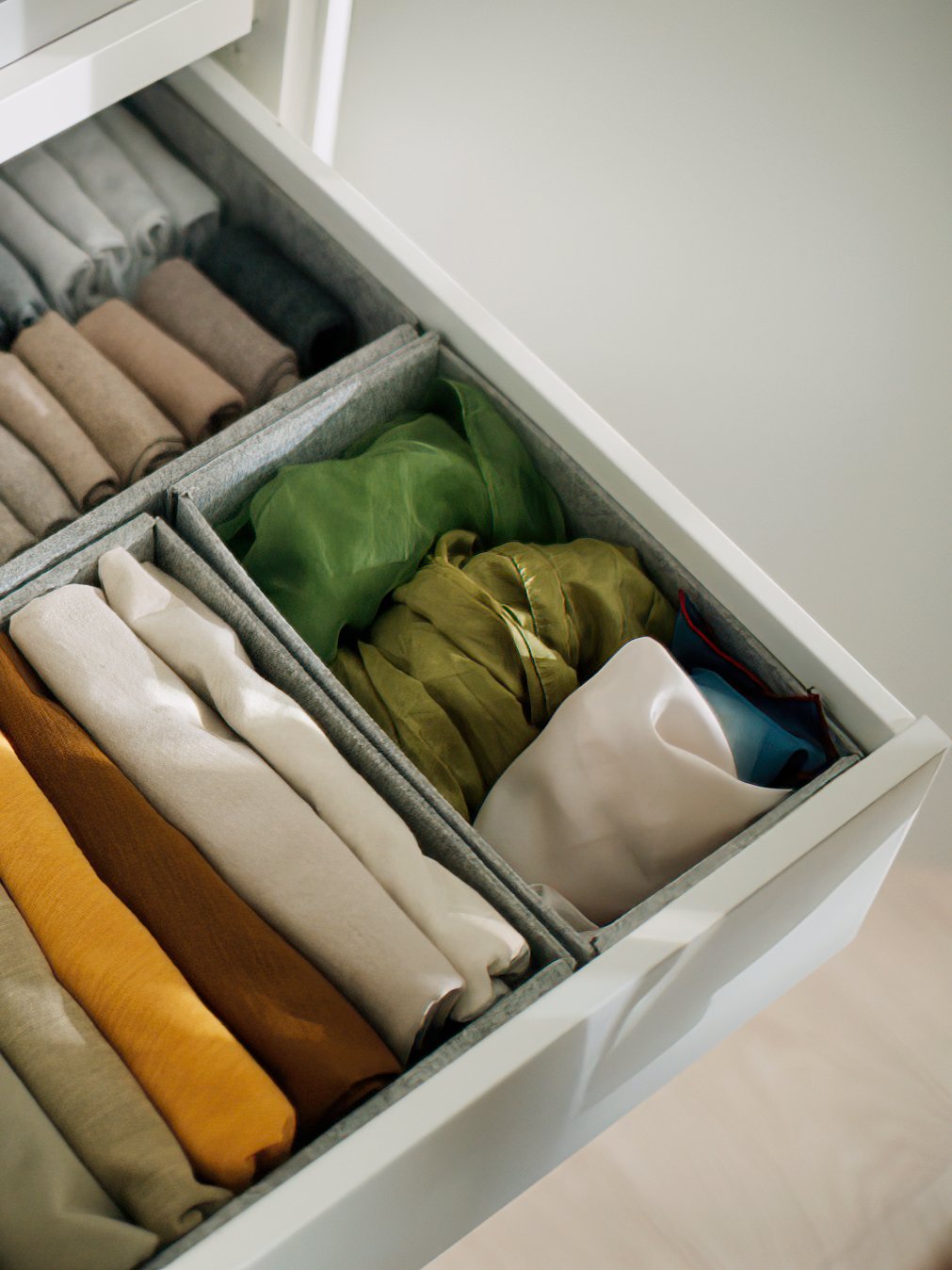 An extended drawer with light grey KOMPLEMENT boxes in different sizes with various items neatly organised in them.