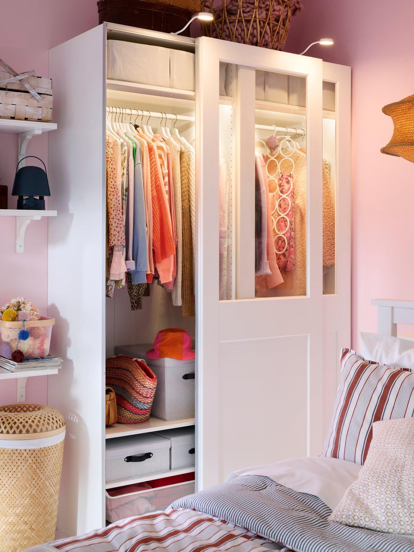 PAX wardrobe with sliding partial glass doors and light both inside and outside. One door open to show the neat order inside.