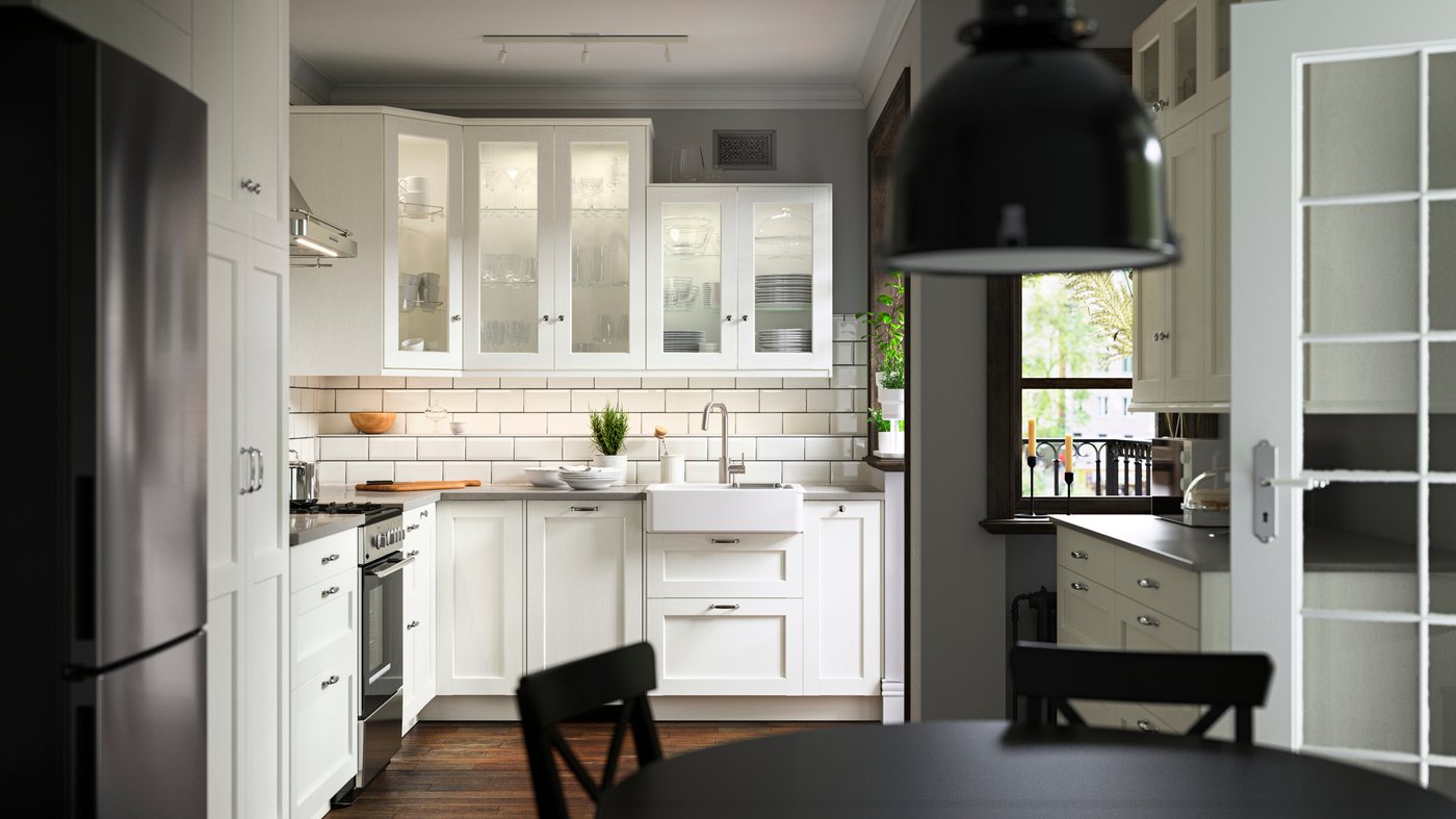 A kitchen with ENKÖPING white fronts, a ÖRMINGE range in stainless steel, a HAVSEN sink bowl and a SVARTNORA pendant lamp.