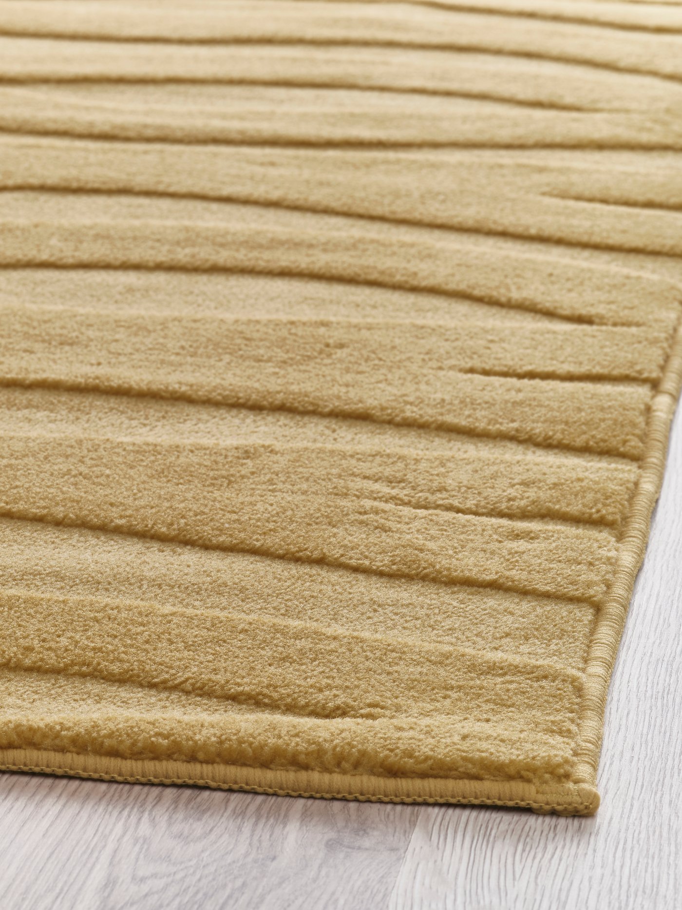 Beige matta med diskret struktur är utrullad på ett golv.