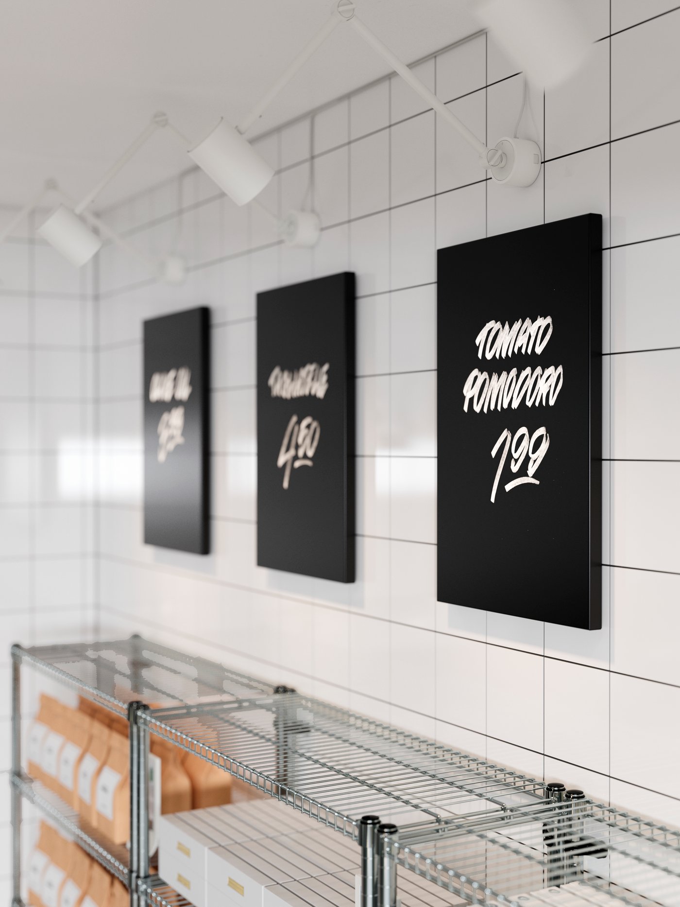 Three black SVENSÅS chalkboards with handwritten prices on, hanging on a white wall with three white spotlights above.