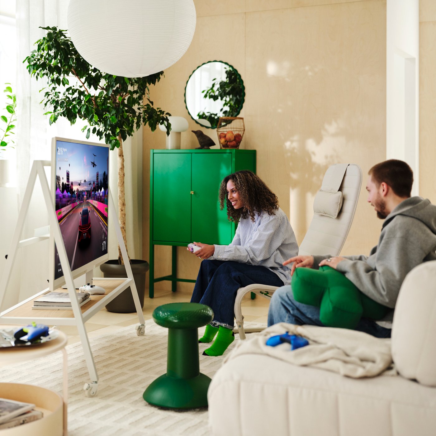 Zwei Personen spielen im Wohnzimmer, umgeben von Produkten aus der YXSTABY Kollektion.