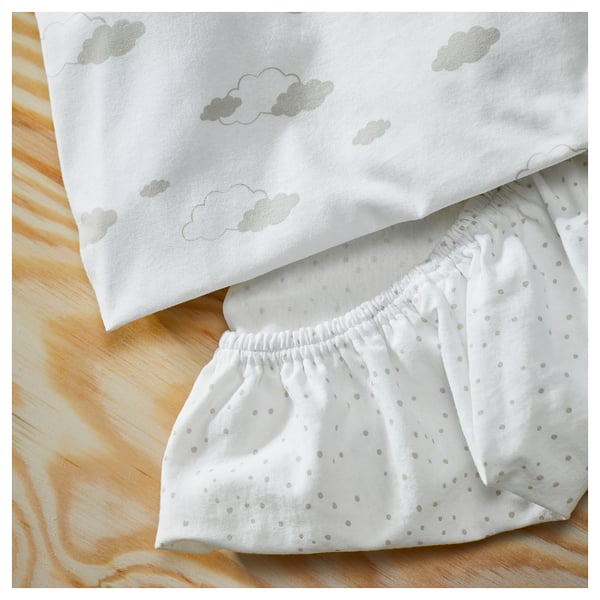 White sheet set with soft clouds and tiny dots, laid out on a wooden floor, showcasing its cosy and crisp cotton quality.