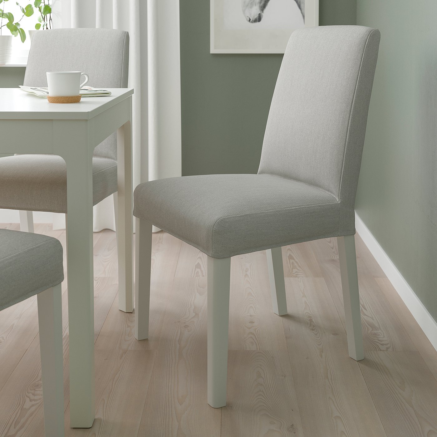 Modern BERGMUND grey chairs near small table with white top and cup.
