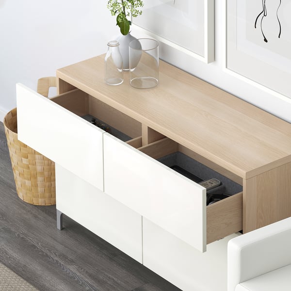Modern BESTÅ storage with remote controls, decor on top.