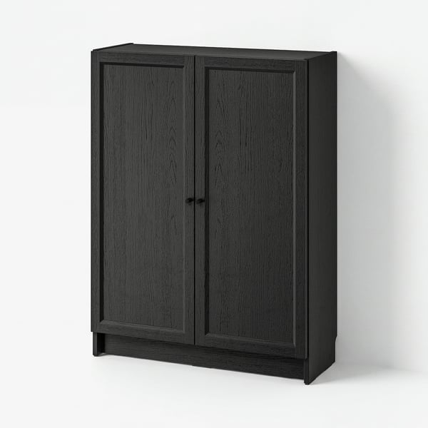 A BILLY bookcase in dark grey with two doors, made from particleboard and fiberboard, featuring a simple and versatile design.