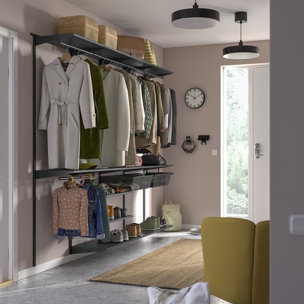 BOAXEL wall storage in closet with shelves & rails, clothes, chair.