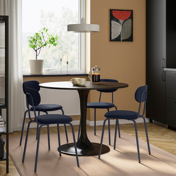 Small, round black DOCKSTA table with three matching blue chairs, suited for cosy spaces.