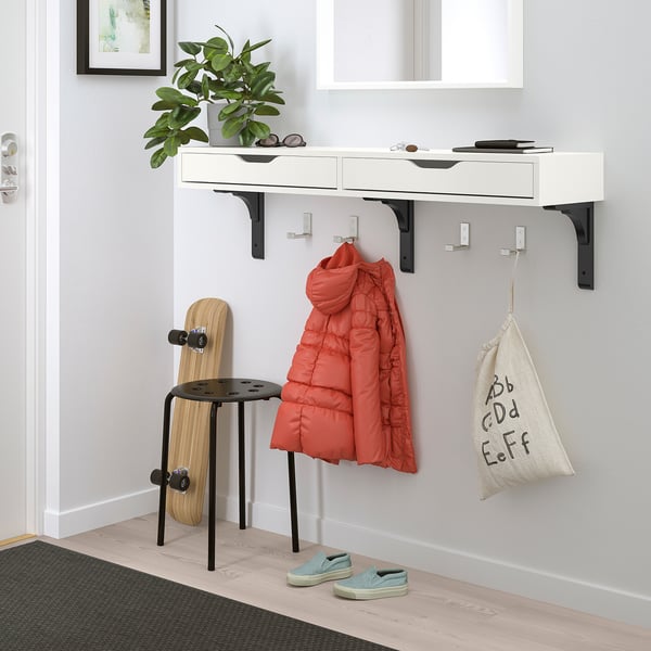 White EKBY ALEX shelf with drawers, skateboard, red jacket, plant, & bag.