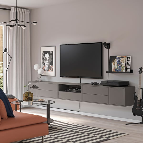 Modern living room with EKET units, tv, orange couch, lamp, guitar, and records.