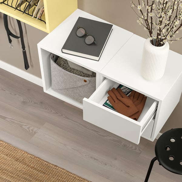 Wall-mounted cabinet with open & closed storage; grey basket, drawer with clothes.