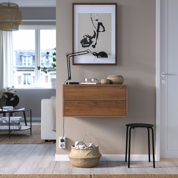 Wooden EKET cabinet with 2 drawers, abstract painting, basket, black stool.