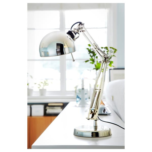 A sleek, adjustable steel desk lamp, angled to provide directional light.