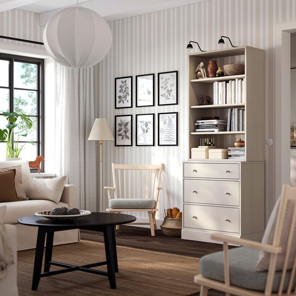 Modern living room with light wood furniture. White HAVSTA chest, black coffee table, beige sofa, wood chair, light curtains.