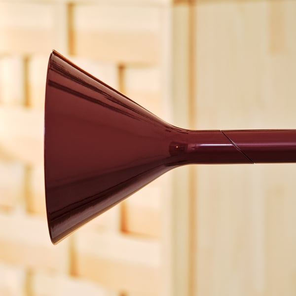 Sleek, modern floor lamp with adjustable, glossy red metallic finish, emitting sophisticated lighting.