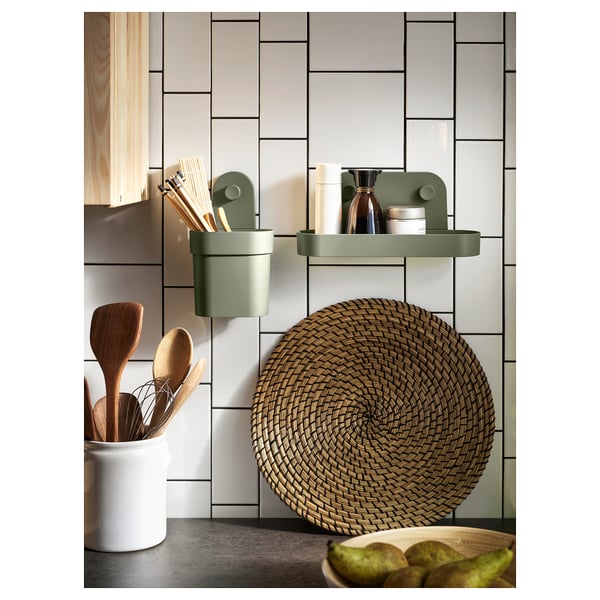 Modern kitchen with green LÄTTAD accessories: cylindrical holder, shelf, and woven placemat.
