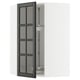 Open METOD kitchen cabinet with black glass doors featuring bevelled edges.
