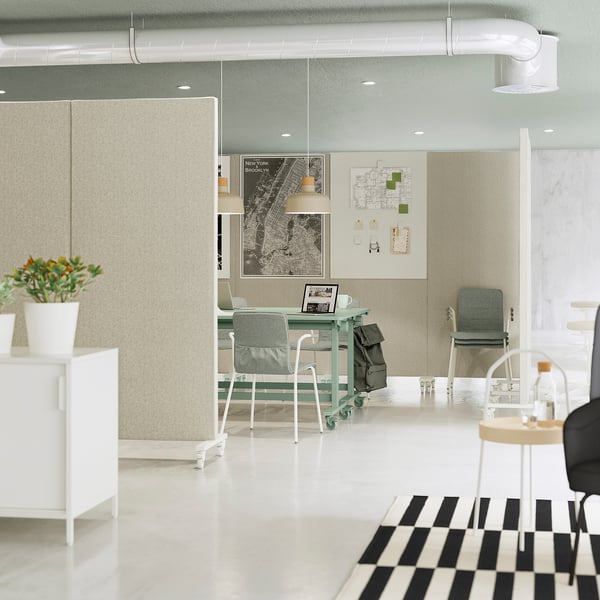 Modern office with MITTZON screens, laptops, green chairs, maps, chequered rug.