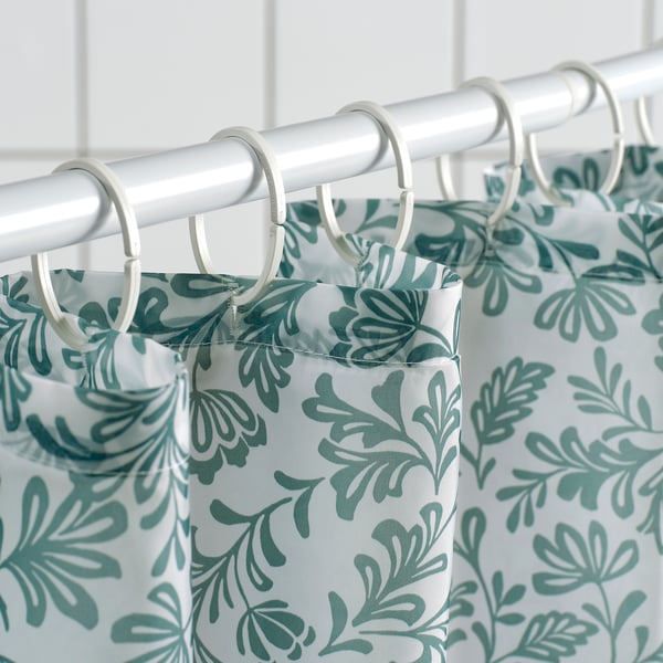 Shower curtain with turquoise leaf pattern hangs on rings. Water-repellent, made from recycled polyester.