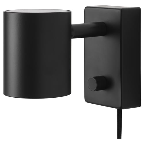 A black NYMÅNE wall lamp with a cylindrical shade and adjustable arm, mounted on a rectangular base.