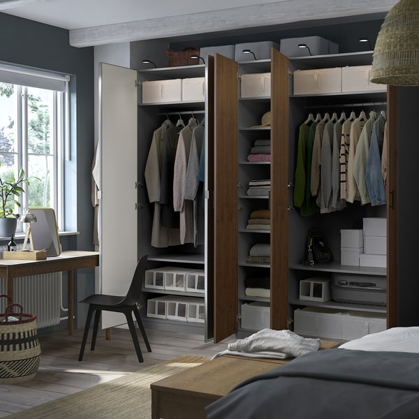 A well-organized PAX wardrobe with shelves and hanging space, featuring storage boxes and clothing items.