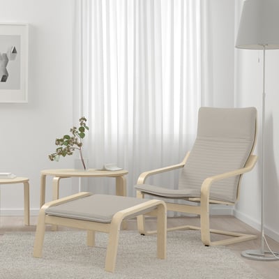 Minimalist living room with light wooden POÄNG chair and ottoman, white curtains, rug, lamp, and small side table with plant.