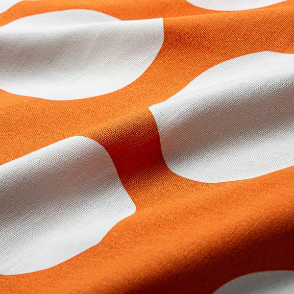 Orange fabric with irregular white dots, textured, recycled cotton.