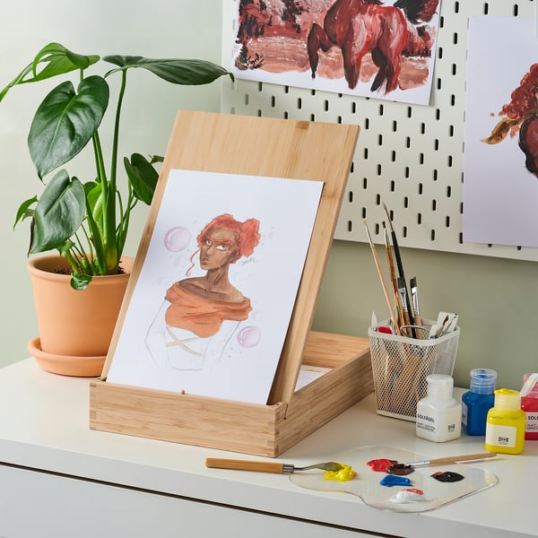 Wooden easel with painting & art supplies.