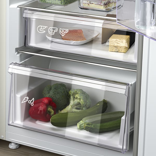 Fridge with adjustable shelves, visible drawers, veggies inside.