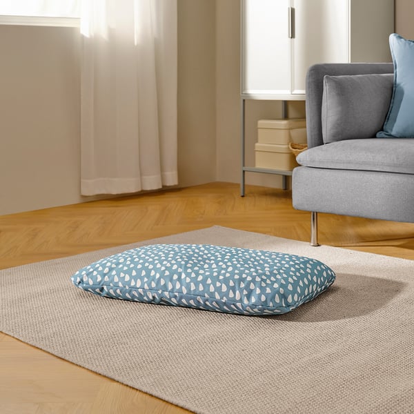 Cushion on rug for pet comfort, with gentle patterns and cosy design.