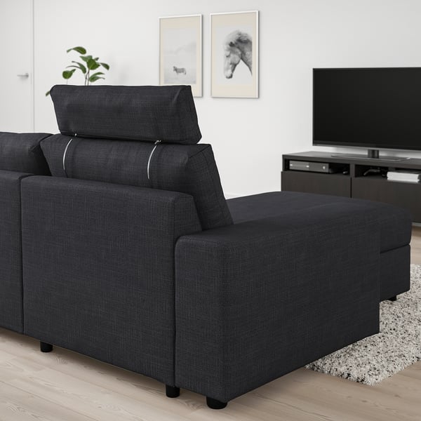 Black VIMLE modular sofa in living room, featuring a reclining chaise longue and adjustable headrest.