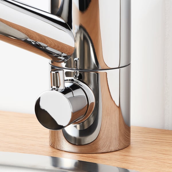 Modern chrome tap mounted on wooden counter, showcasing sleek design and durable materials.