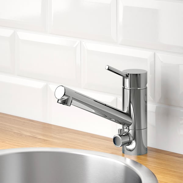 Modern chrome kitchen tap with pull-out sprayer on wooden countertop, featuring water and energy-saving aerator.