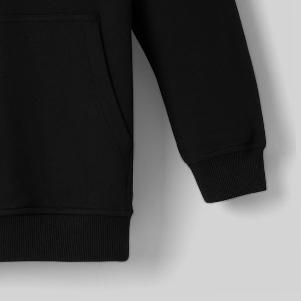 Svart hoodie-detalj, som visar upp mjuk bomullsstruktur, ribbade muddar och fåll, elegant design.